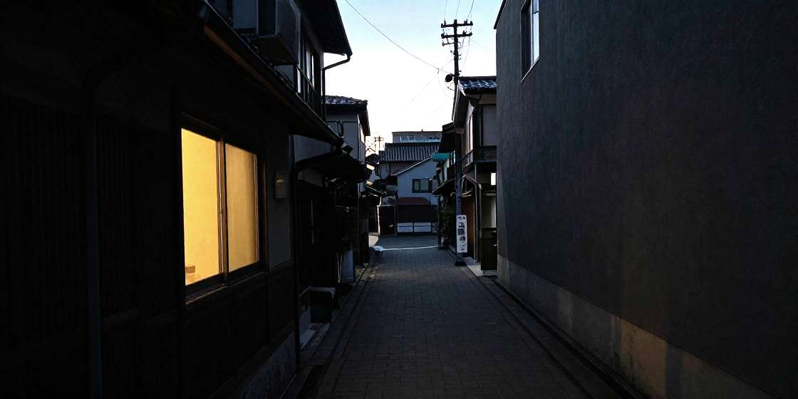 夕方の大阪の路地と窓明かり